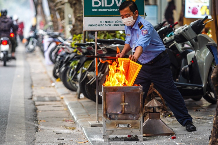 Người dân đem vàng mã ngay trên vỉa hè phố Hàng Bông, nơi có nhiều người dân và du khách qua lại.