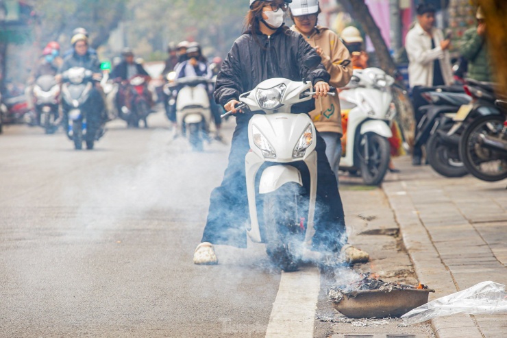 "Tầm 11h, em thấy mọi người bắt đầu mang đồ mã ra vỉa hè, lòng đường để đốt. Khói cùng với bụi giấy bay ra ngoài đường gây khó chịu cho mũi và mắt, rất nguy hiểm nếu như đang lái xe", Hà Anh (Cầu Giấy, Hà Nội) chia sẻ.