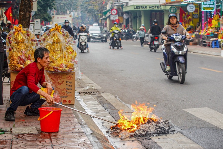 Người dân đốt vàng mã ngay dưới vỉa hè phố Hàng Than.