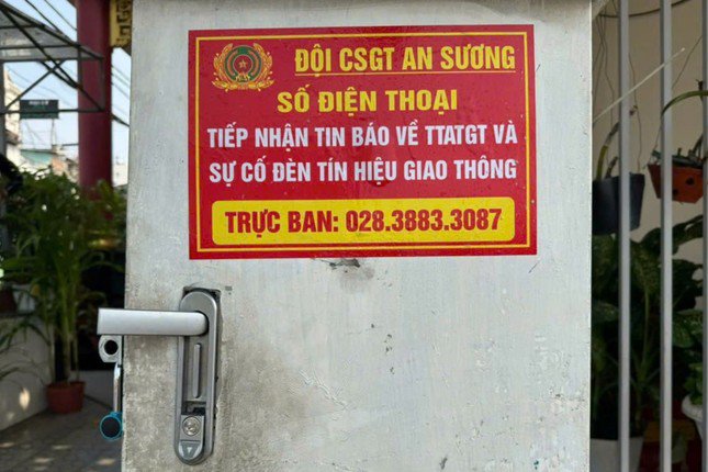 Số điện thoại của Đội CSGT An Sương được niêm yết tại tủ điều khiển để người dân phản ánh khi có sự cố về đèn tín hiệu. Ảnh: PC08.