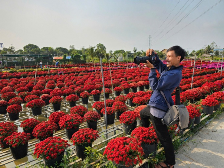 Nhiếp ảnh tươi cười chụp ảnh cho du khách. Ảnh: Hòa Hội