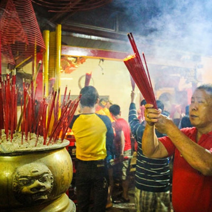 Người đàn ông thắp hương ở một ngôi đền ở&nbsp;Indonesia, cầu năm mới bình an, thuận lợi (ảnh: Indoindians)