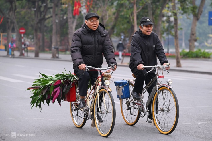 Người dân thong thả đạp xe trên các con phố quanh hồ Hoàn Kiếm, dưới thời tiết 13-14 độ C.