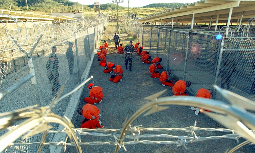 Tù nhân mặc áo cam, quỳ trên nền đất tại nhà tù Guantanamo (ảnh: US Navy)