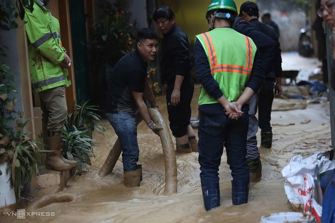 Công nhân hút bùn ra khỏi ngõ. Ảnh: Phạm Chiểu