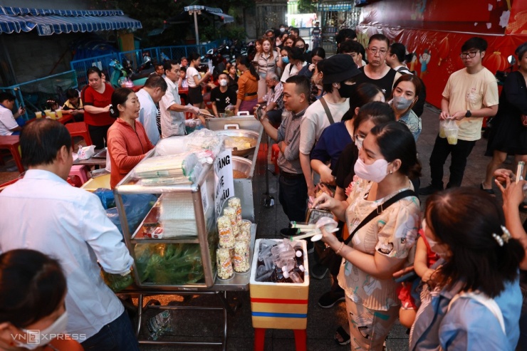 18h ngày 21/2, khoảng sân bên hông chùa Ông chật kín người xếp hàng mua đậu hũ vàng chiên.