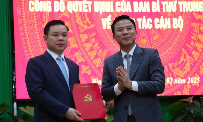 Ông Đỗ Trọng Hưng, Phó ban Tổ chức Trung ương (phải) trao quyết định cho ông Đỗ Hữu Huy, sáng 26/2. Ảnh: Việt Quốc