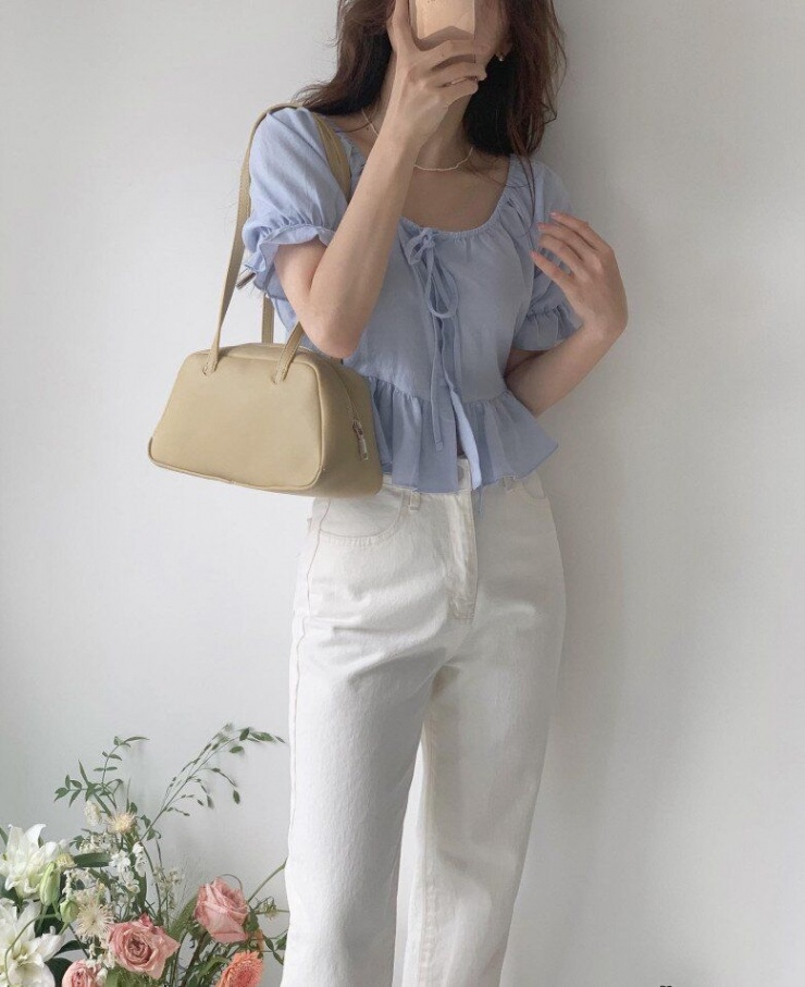 Sự kết hợp giữa áo blouse xanh pastel dáng peplum và quần trắng mang lại vẻ ngoài nữ tính, nhẹ nhàng nhưng vẫn có chút cổ điển. Chi tiết thắt nơ trước ngực và tay bồng giúp tạo điểm nhấn mềm mại.