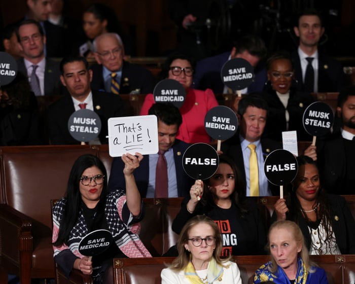 Nhiều nghị sĩ đảng Dân chủ giơ biểu ngữ trong lúc ông Trump phát biểu. Ảnh: Reuters