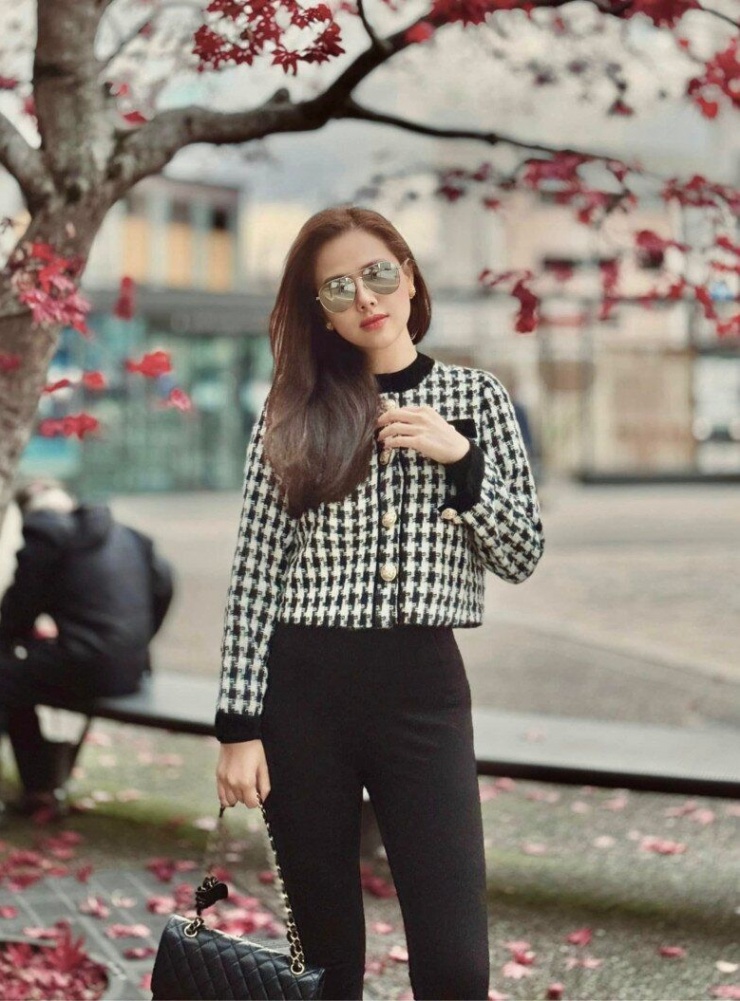 Một set đồ mang đậm chất quý phái với chiếc áo khoác lửng họa tiết houndstooth, điểm xuyết những chiếc cúc ánh vàng sang trọng. Cách phối với quần đen ôm sát tạo nên sự hài hòa giữa cổ điển và hiện đại.