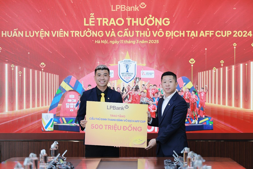 Ông Vũ Quốc Khánh, Tổng Giám đốc LPBank (phải) trao tặng 500 triệu đồng cho cầu thủ Đinh Thanh Bình