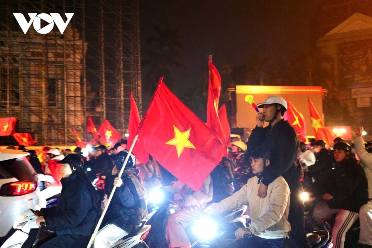 Cờ Tổ quốc tung bay trong mưa nhẹ, sắc đỏ phủ kín các tuyến phố trung tâm.