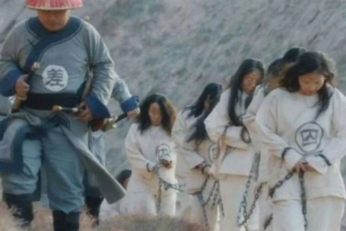 Du khách mặc áo in chữ "tù nhân'', đeo xiềng xích mang tính biểu trưng. Ảnh: SCMP