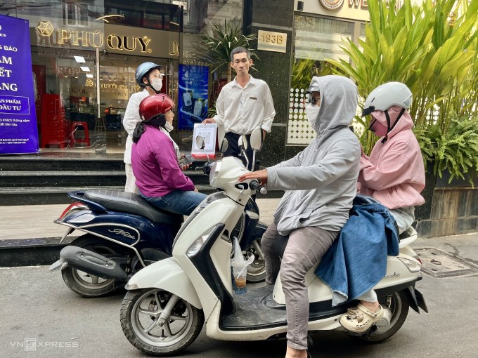 Nhân viên Phú Quý tại chi nhánh TP HCM hướng dẫn người mua tham gia nhóm Zalo khi nhiều người dân liên tục tới hỏi mua bạc miếng sáng 31/1, cửa hàng không nhận đăng ký mua trong các ngày cuối tuần. Ảnh: Quỳnh Trang