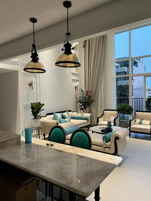 Khu vực bàn ăn có ghế và một bàn chữ nhật lớn màu kem. Nam ca sĩ còn bài trí thêm đèn chùm để tăng phần lãng mạn.