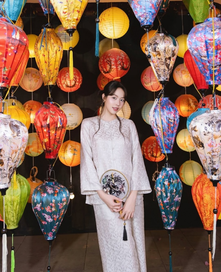 Hoa hậu Thanh Thủy phối trang phục cùng quạt giấy.