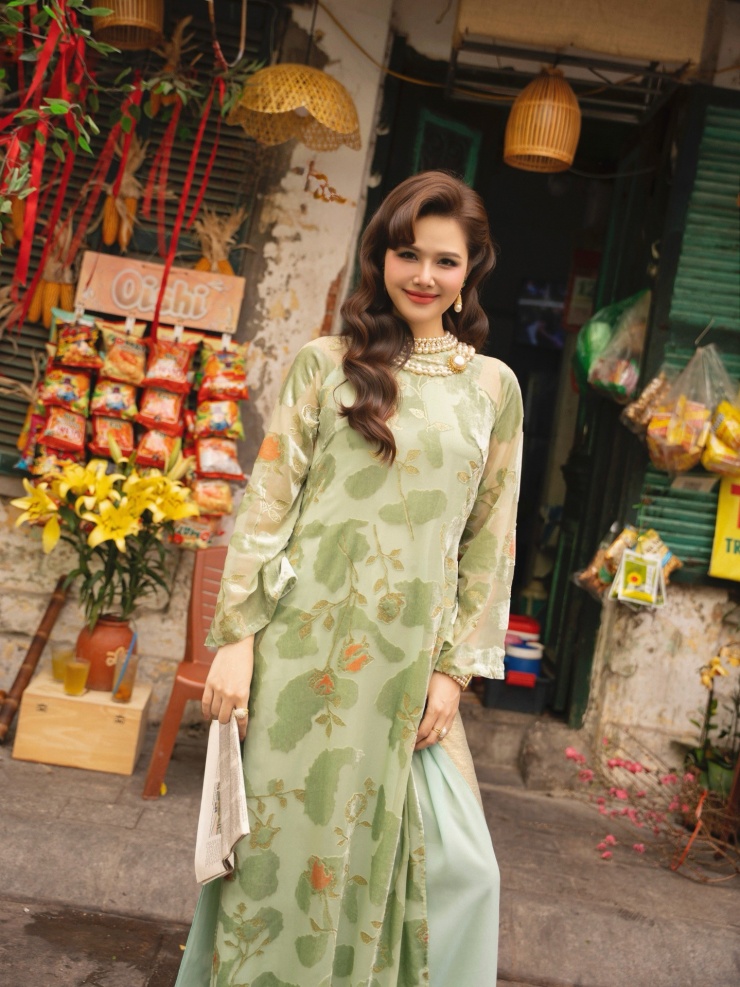 Không gian chụp ảnh được lựa chọn kỹ lưỡng với bối cảnh phố cổ, cửa gỗ cũ, những vật dụng quen thuộc như tờ báo, ly trà, giỏ hoa… Từng chi tiết nhỏ đều góp phần kể câu chuyện về một Hà Nội trầm mặc, hoài niệm.