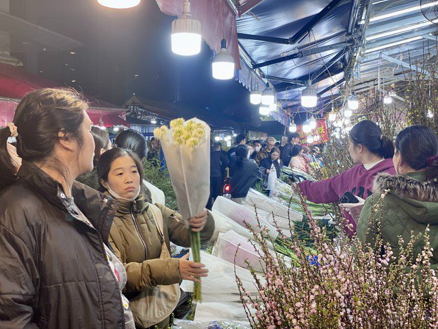 Nhiều người dân tranh thủ đến chợ đầu mối hoa lớn nhất Thủ đô để chọn những cành hoa đẹp nhất, tươi nhất để dâng lễ trong ngày Rằm tháng Giêng.