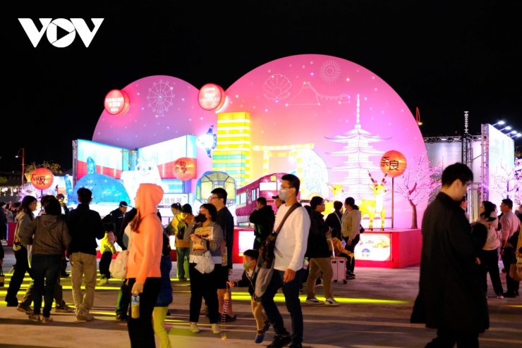 Hàng nghìn du khách trong và ngoài nước đổ về chiêm ngưỡng, chụp ảnh, cầm đèn lồng dạo bước giữa các khu trưng bày rực rỡ, tạo nên bầu không khí lễ hội sôi động suốt đêm xuân.