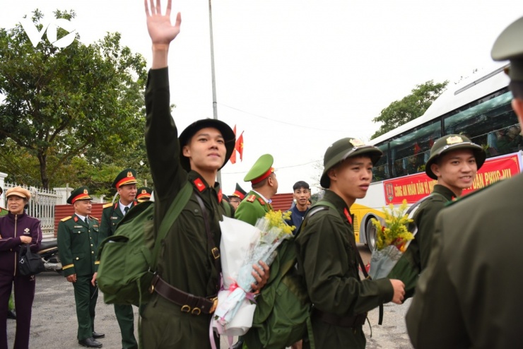 Một tân binh vẫy tay chào gia đình, người thân trước khi lên đường.