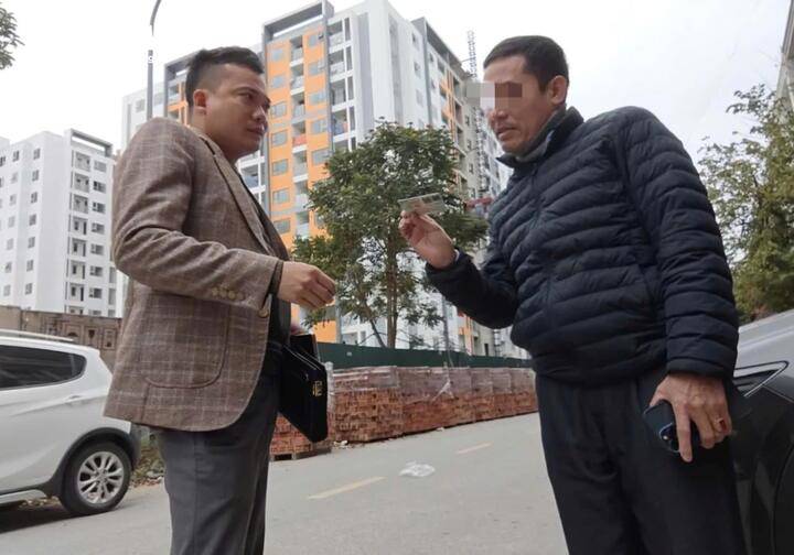 Môi giới tên Minh cẩn thận xem CCCD của người muốn mua lại nhà ở xã hội Tùng Bách.