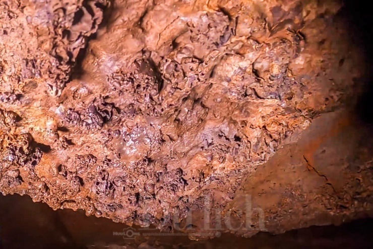 Dưới ánh sáng trắng nhờ từ đèn pin chiếu rọi, đập vào vách đá hiện lên sắc màu đỏ quạch, bàng bạc lấp loáng, tất cả hiện ra kỳ ảo, vừa hư vừa thực.