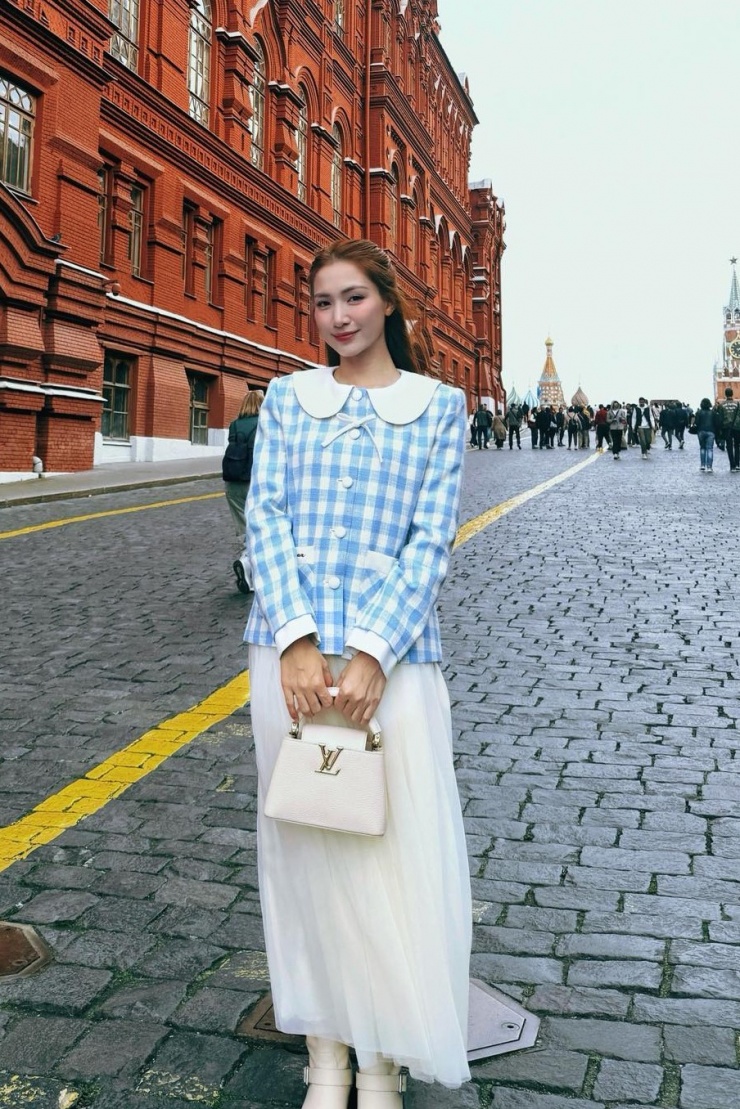 Trên đường phố nước Nga, Hòa Minzy xách túi Louis Vuitton Capucines màu trắng giá hơn 190 triệu đồng, là một món quà mà đối tác tặng cô dịp sinh nhật.