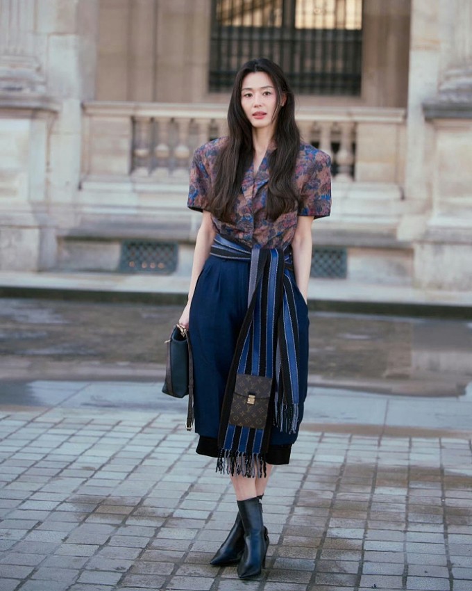 Diễn viên Hàn Quốc Jeon Ji Hyun đến dự show với sơ mi hoa kết hợp váy midi sắc xanh thẫm. Một số khán giả nhận xét 'vóc dáng cao ráo của cô ấy rất hợp với LV' và 'vẫn giữ được thần thái siêu sao', trong khi những người khác lại chú ý đến quầng thâm mắt và vẻ ngoài mệt mỏi của diễn viên.