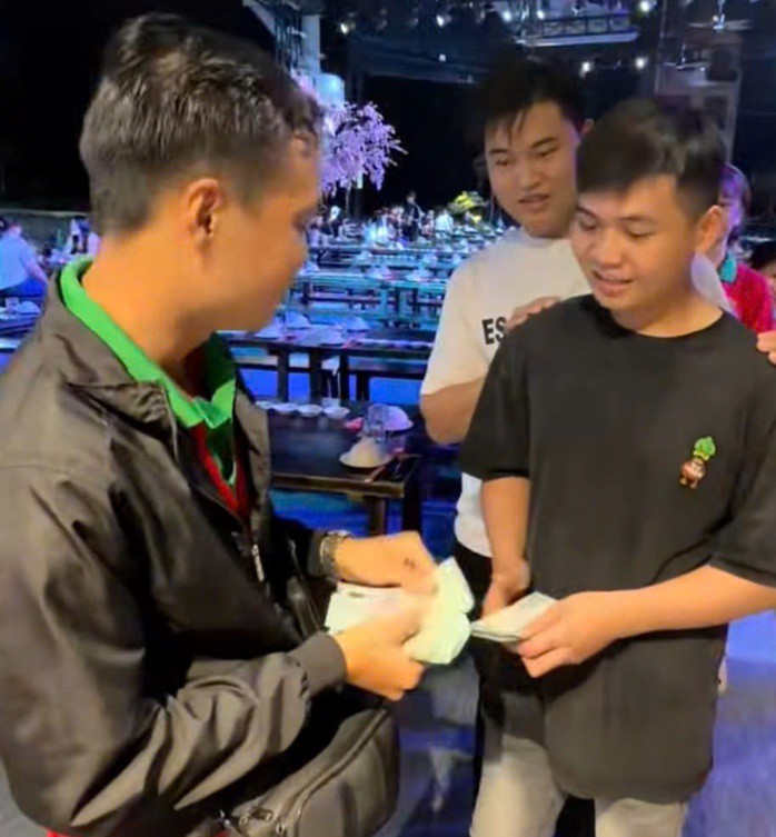 Anh Phát tặng tiền trúng độc đắc cho nhiều người trong quán. Ảnh cắt ra từ clip
