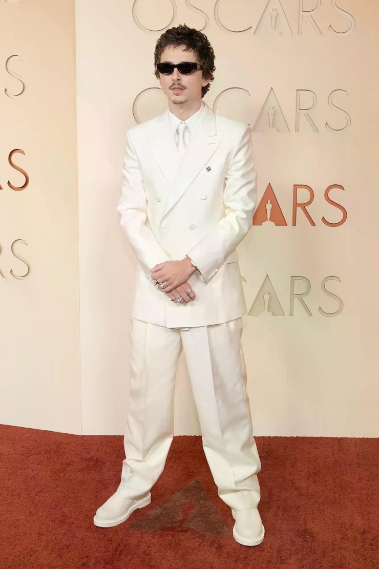 Timothée Chalamet vướng phải ồn ào khiến cơ hội chiến thắng Oscar của nam diễn viên không còn chắc chắn. Timothée xuất hiện tại thảm đỏ với trang phục trắng ton sur ton của nhà mốt Givenchy, kết hợp phụ kiện kính râm cá tính.