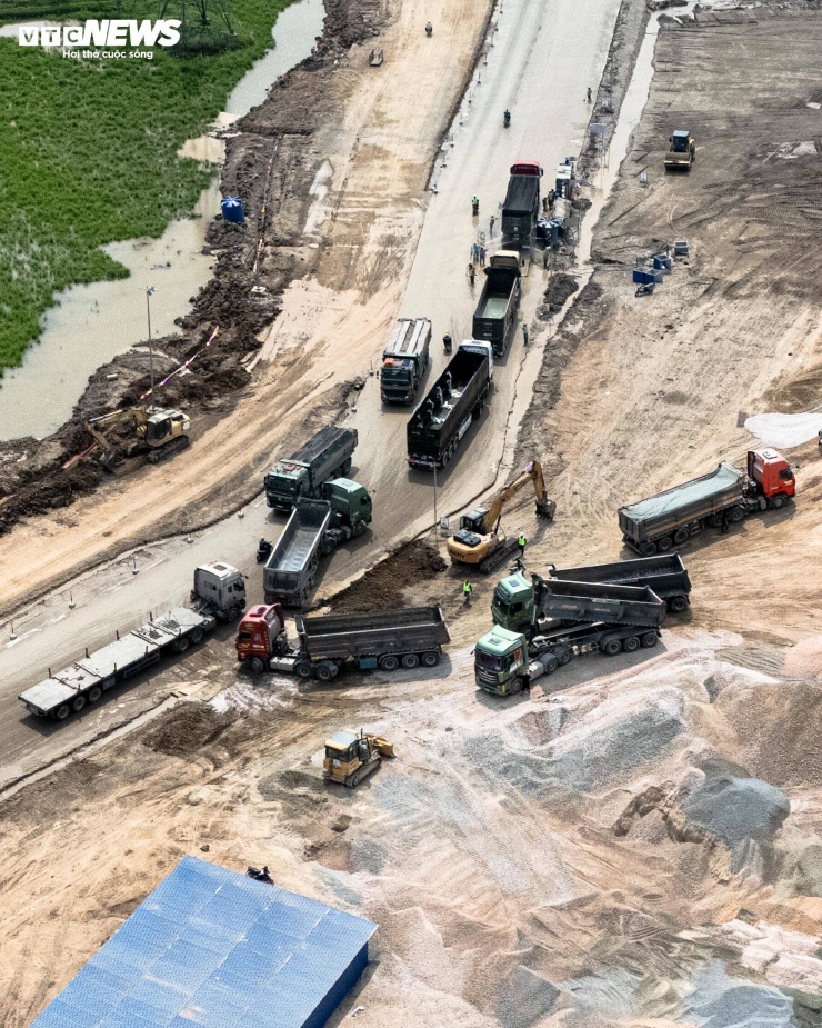 Các máy xúc, máy ủi hoạt động liên tục, trong khi xe tải trọng lớn tấp nập vận chuyển đất, đá.