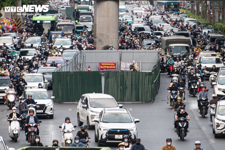 Ô tô gần như không thể chạy nhanh, trong khi xe máy phải len lỏi qua những khoảng trống hẹp giữa các dải rào tôn và dòng phương tiện phía trước.