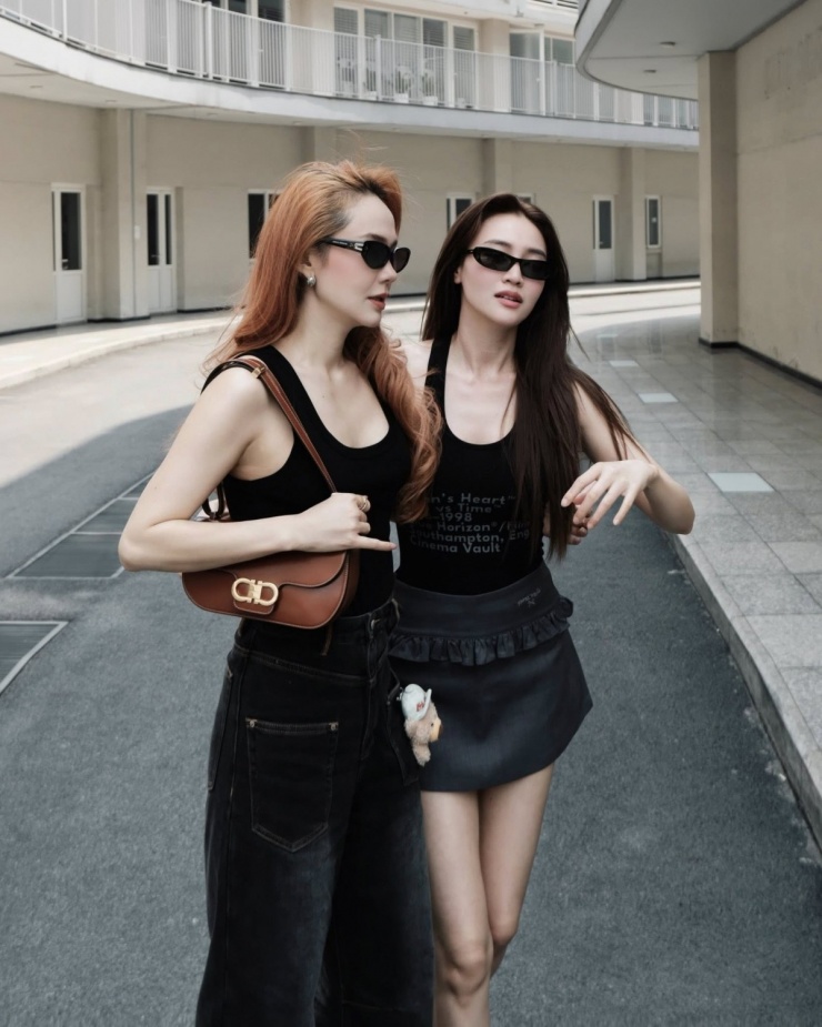 Cả hai chọn phong cách tối giản với áo thun ba lỗ màu đen, phối cùng quần và váy tông trầm. Trong khi Lan Ngọc giữ vẻ ngoài nhẹ nhàng, Minh Hằng tạo điểm nhấn bằng loạt phụ kiện hàng hiệu.