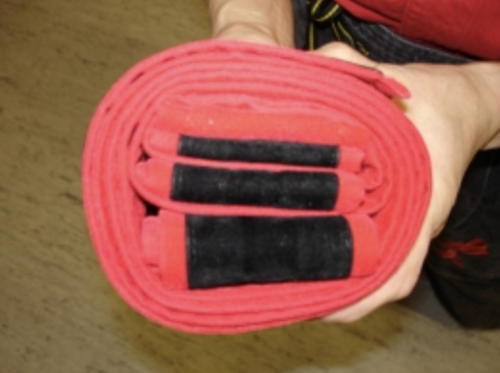 Chiếc đai đen được gấp gọn thuộc về một bậc thầy Kung Fu To'A. Ba nếp gấp với kích thước khác nhau tượng trưng cho "Suy nghĩ tốt - Lời nói tốt - Hành động tốt."