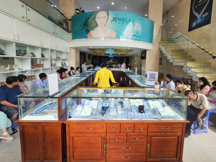 Rất đông khách hàng xếp hàng ngồi 2 bên để đợi đến lượt mua vàng