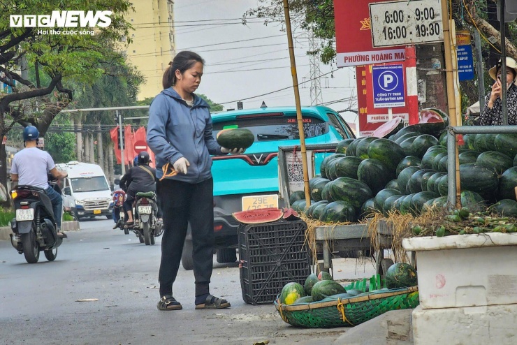 Dọc lối ra vào chợ, một số tiểu thương vẫn bày bán hoa quả, dựng ô dù trên vỉa hè, thậm chí có thời điểm lấn ra sát mép đường.