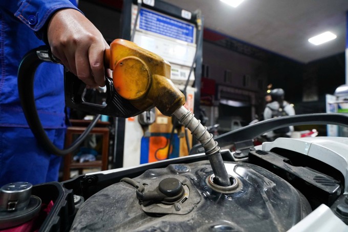 Nhân viên tại cây xăng trên đường Xuân Thủy (Cầu Giấy, Hà Nội) đổ nhiên liệu cho khách, ngày 16/3. Ảnh: Hoàng Giang