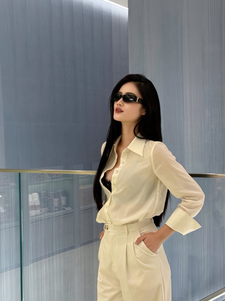 Cũng diện sơ mi mỏng manh, hoa hậu Ý Nhi bổ sung nét gợi cảm khi áp dụng mốt khoe bra màu tương phản.