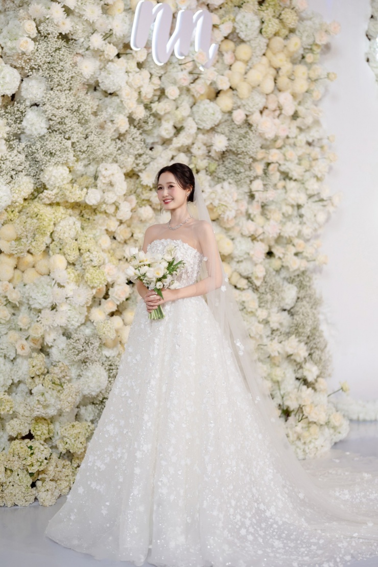 Chân váy nhiều lớp kết hợp sequin ánh xà cừ mang lại hiệu ứng chuyển động mềm mại, trong khi chiếc veil dài tiếp tục phát triển hình ảnh hoa nở.