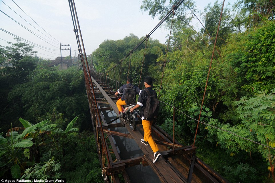 Một số người thậm chí còn đi xe máy dọc những tấm gỗ hẹp, bất chấp nguy hiểm có thể ngã khỏi cầu.
