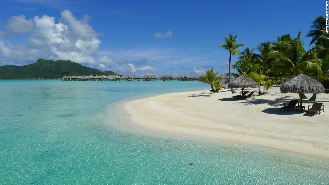 Đảo Bora Bora ở Polynésie, Pháp. Bora Bora được mệnh danh là “thiên đường của những đôi tình nhân” với làn nước trong xanh, không khí trong lành thấm đượm hương biển. Đảo được bao bọc bởi một đầm nước mặn và một hàng rào chắn bằng đá ngầm, khiến cho hòn đảo có một màu sáng rực trên nền nước biển xanh đậm.