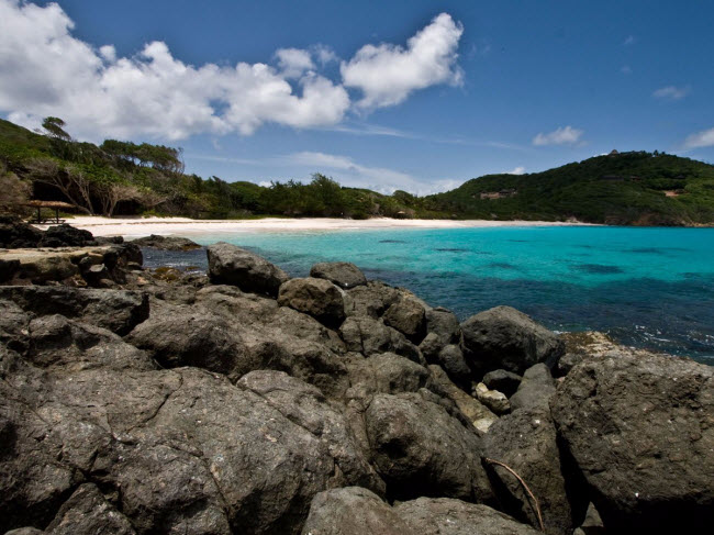 Đảo Mustique ở St. Vincent và Grenadines có bãi biển Macaroni khuất sau những dãy núi. Đây là địa điểm lý tưởng cho mọi người cắm trại, lặn ống thở và tận hưởng không gian yên tĩnh.