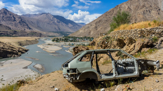 Vỏ một chiếc ô tô nằm trên bờ sông gần thị trấn Khorog thuộc khu tự trị Gorno-Badakhshan, Tajikistan.