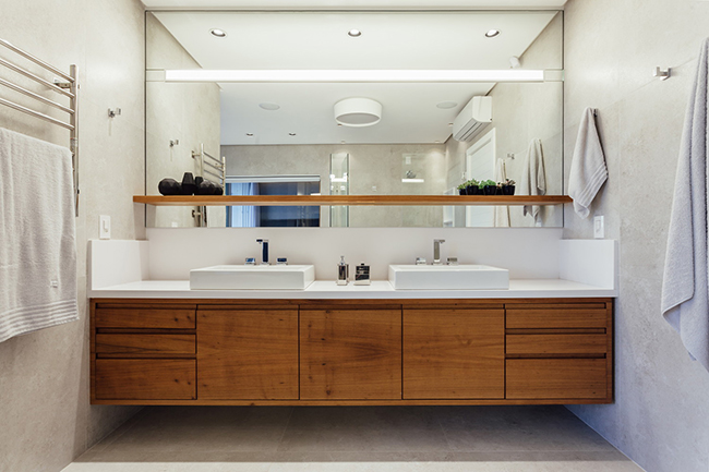 Trong một phòng tắm đơn giản hiện đại với tường xi măng và sàn gỗ.