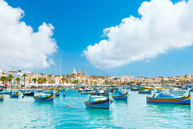Marsaxlokk, Malta: Bạn sẽ tìm thấy ngôi làng đánh cá nhỏ này trên bờ biển phía đông nam của Malta. Cảng biển có vô số thuyền cá màu sắc bắt mắt hấp dẫn khắp du lịch. Ngoài ra, hải sản tươi rói và thơm ngon cũng là yếu tố hút du khách tới đây.