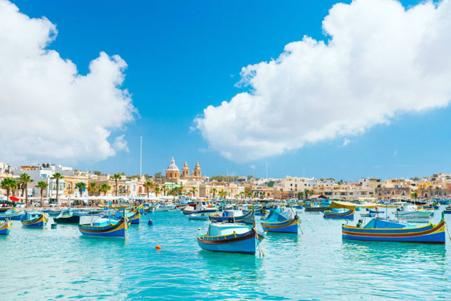 Marsaxlokk, Malta: Bạn sẽ tìm thấy ngôi làng đánh cá nhỏ này trên bờ biển phía đông nam của Malta.&nbsp;Cảng biển có vô số thuyền cá màu sắc bắt mắt hấp dẫn khắp du lịch. Ngoài ra, hải sản tươi rói và thơm ngon cũng là yếu tố hút du khách tới đây.