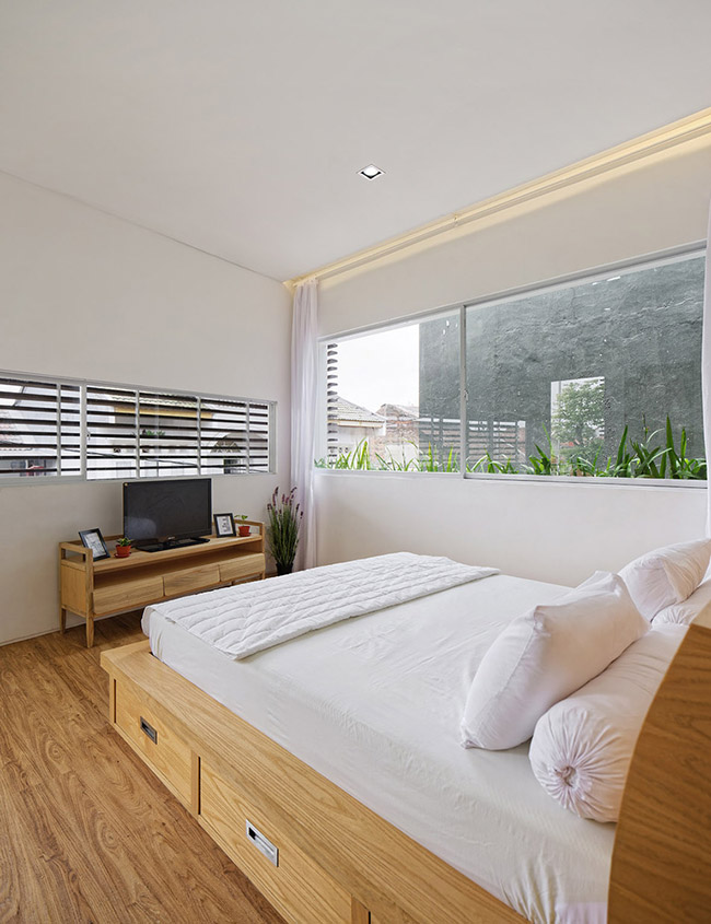 Phòng ngủ chính với đồ nội thất đơn giản và một không gian thoáng đãng, tràn ngập ánh sáng tự nhiên.