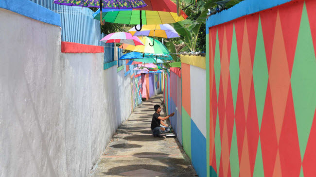 Nghệ sĩ trang trí tại ngôi làng cầu vồng Malay, điểm du lịch hấp dẫn tại Tanjung Pinang, Indonesia.