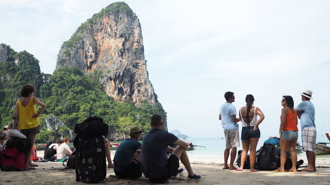 Du khách ngồi chờ dưới bóng mát&nbsp;trên bãi biển Railay West để di chuyển bằng phà tới quần đảo Phi Phi.