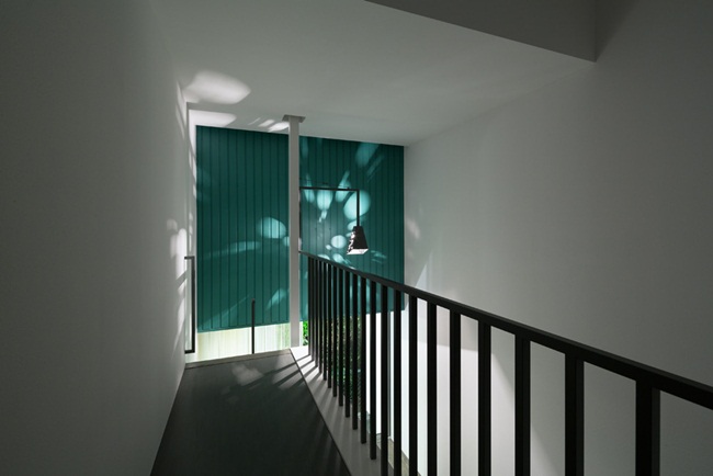 Một hành lang bên trái nối từ phòng ngủ tới một cầu thang sắt áp vào tường được lắp đặt để kết nối trên và dưới